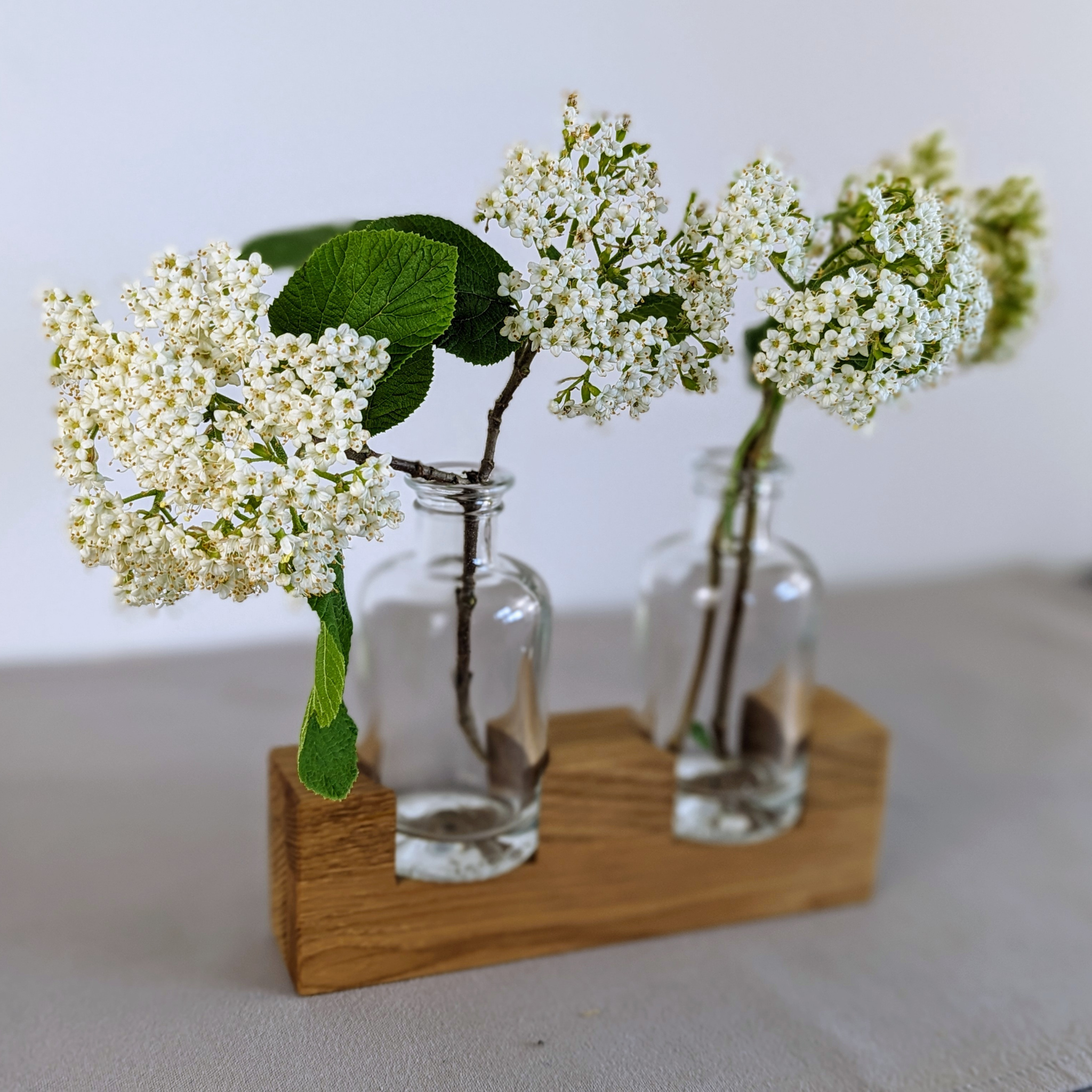 Blumenständer aus Eichenholz mit Apothekerfläschchen